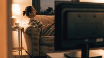 Mulher assistindo televisão na sala à noite